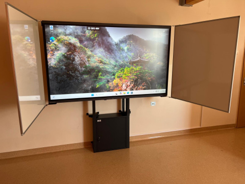 Regulowany elektrycznie stojak z suchościeralną tablicą skrzydłową dla monitora 65" Regulowany elektrycznie stojak z suchościeralną tablicą skrzydłową dla monitora 65"